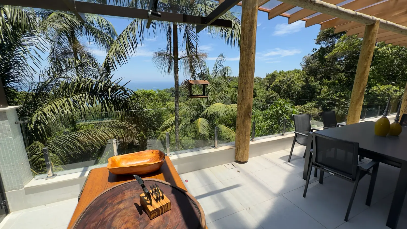 Mesa da varanda da Villa 231 com vista para o mar e paisagem tropical.