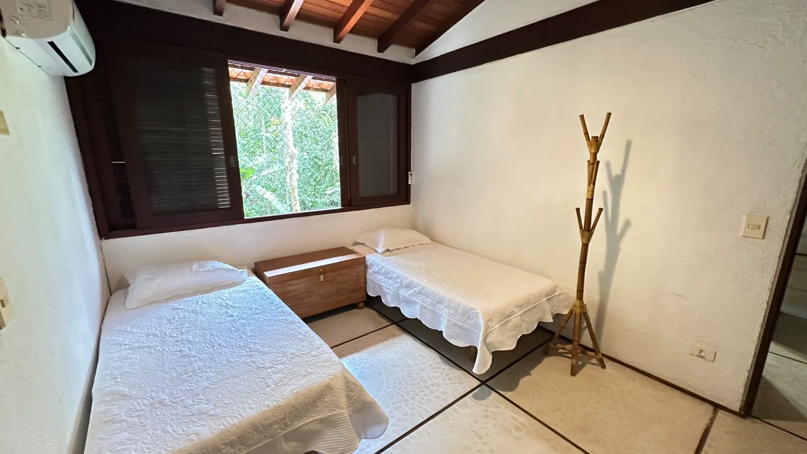 Villa 411 - Casa à venda Condominio Iporanga - Quarto com 2 camas de solteiro, baú de madeira entre as camas e cabideiro de chão.